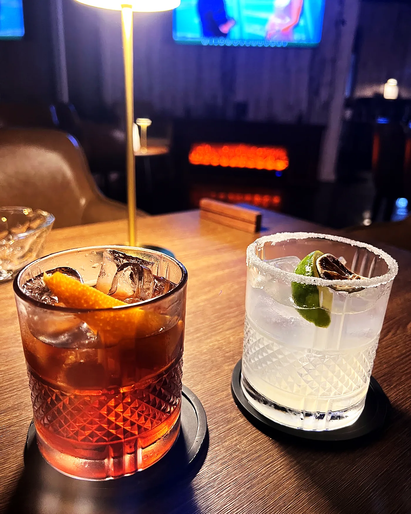 An old fashioned and a mojito on a timber table