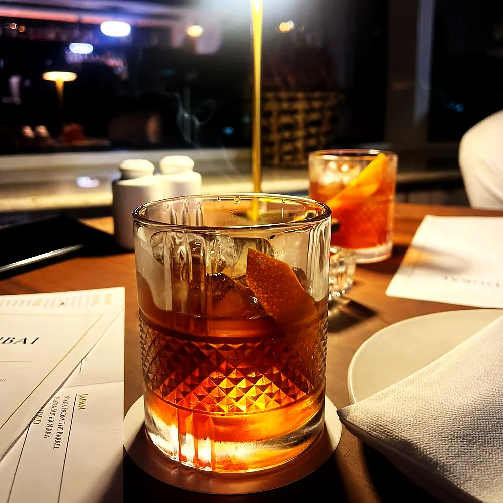 A whisky old fashioned served over a single large ice cube at the Wild Woven bar