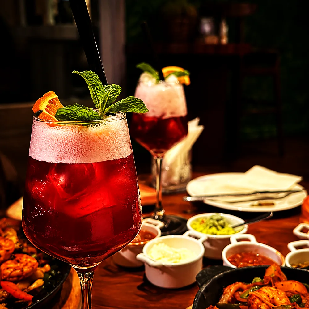 Cocktails set down on a table of sharing plates