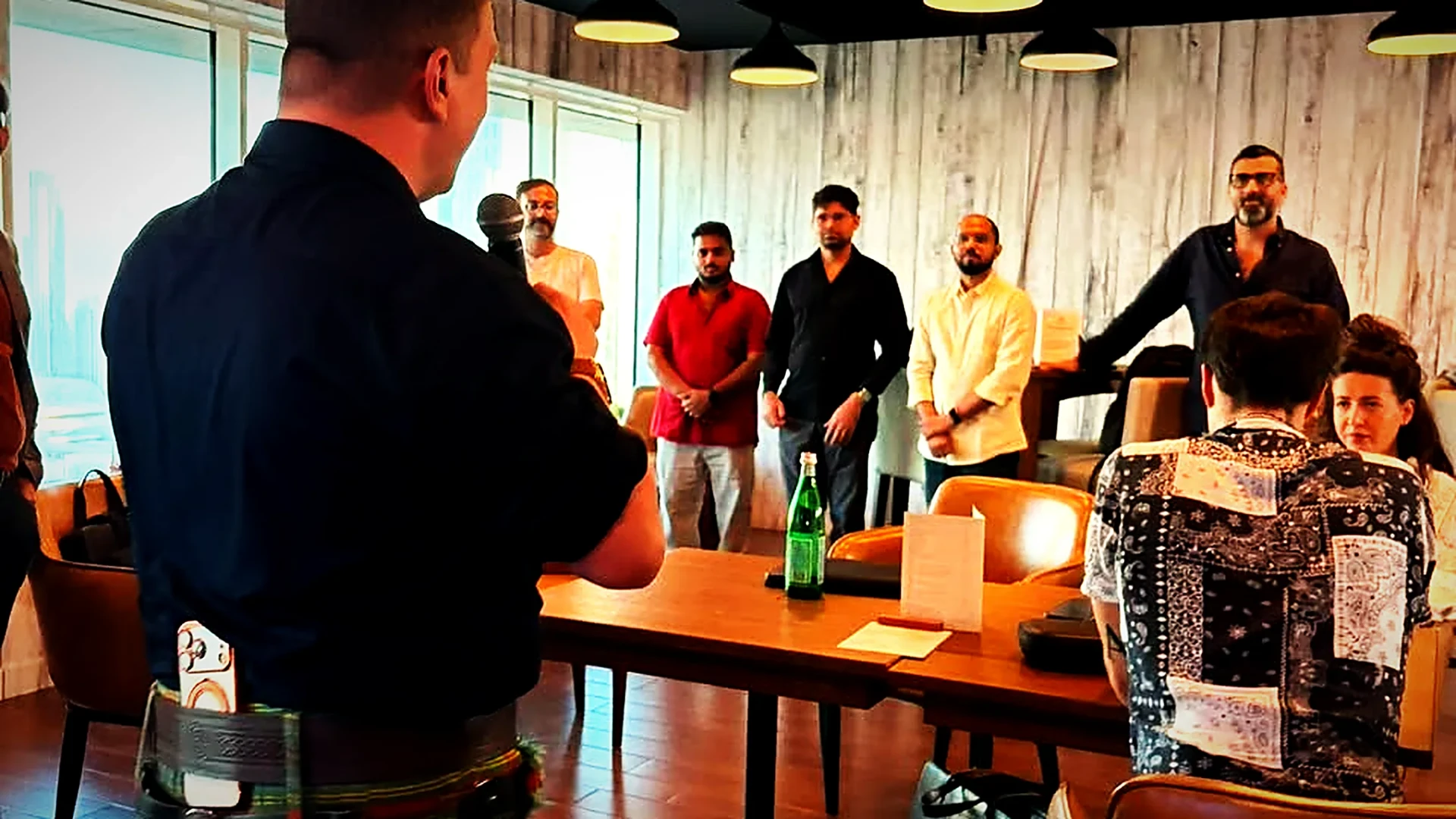 A host in a kilt addressing a full room of guests at Wild Woven Dubai