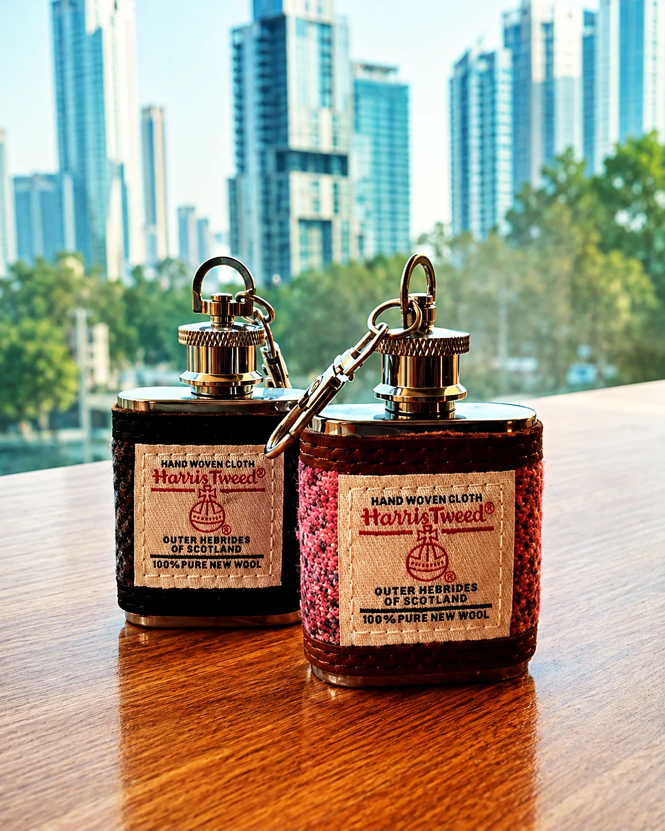 A pair of Harris Tweed hip flasks on a timber table