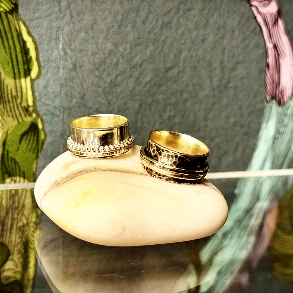 A pair of silver rings resting on a stone
