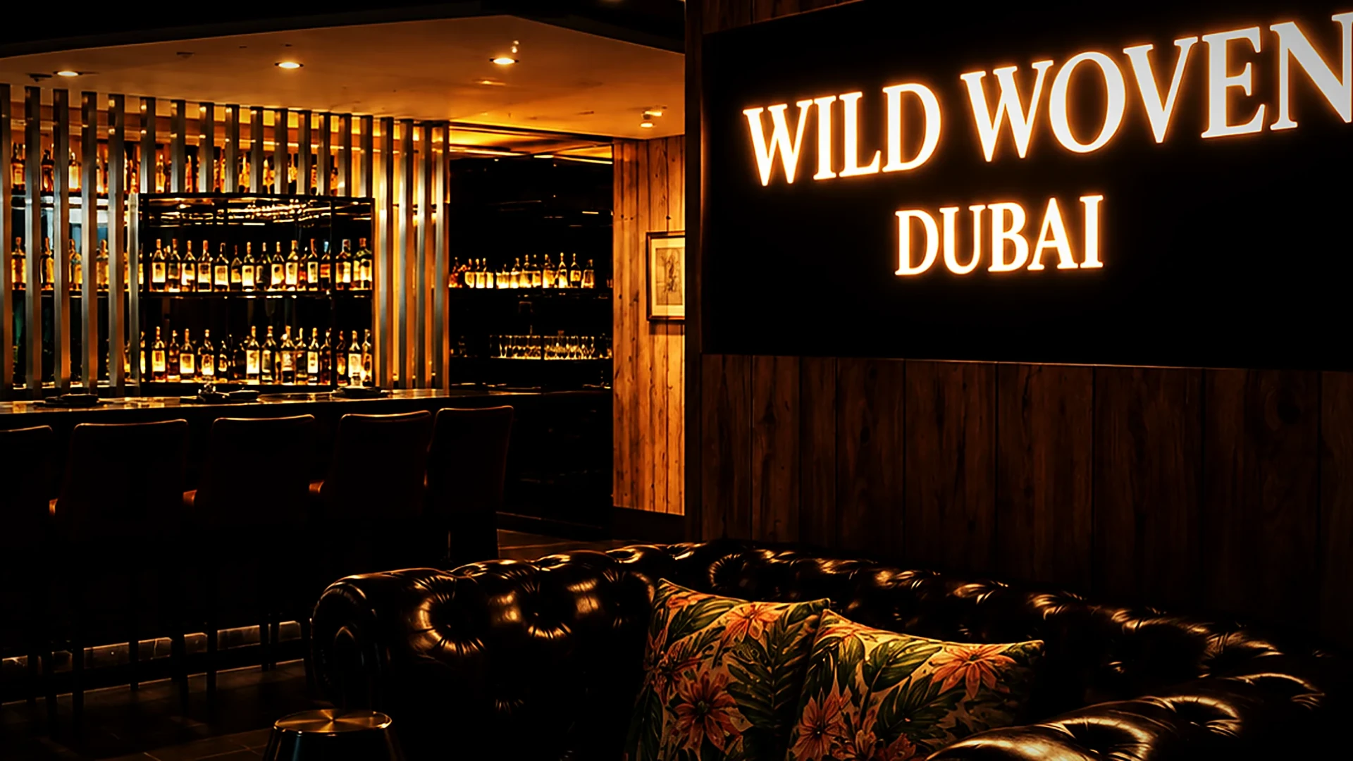 The illuminated Wild Woven Dubai sign above a leather sofa