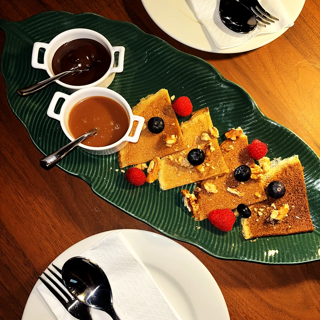 A dessert board with berries and dipping sauces