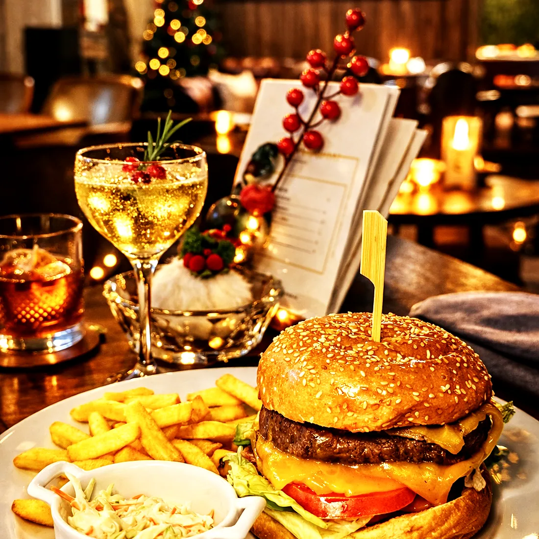 A burger, chips and cocktails on a candlelit table